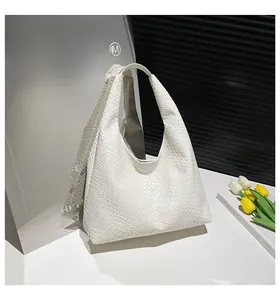 Detail of white woven leather hobo bag showing large capacity and premium texture