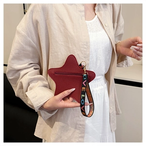 Detailed shot of red star-shaped purse with lychee texture leather and LOVE strap