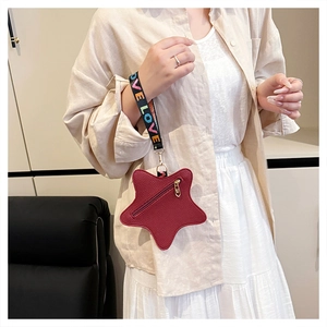 Detail view of red star-shaped bag with lychee leather texture and LOVE woven strap