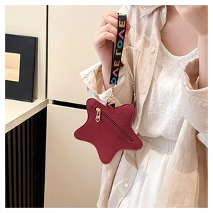 Close-up of star-shaped wine red coin purse with litchi grain texture and strap