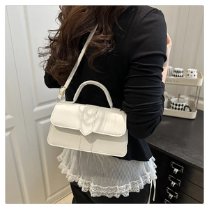 Vue arrière du sac bandoulière blanc avec rabat en V et surpiqûres décoratives porté