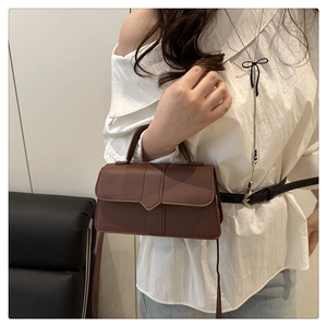 Détail d'un petit sac à main carré marron avec rabat et bandoulière élégante