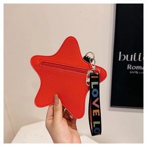 Detail of red star shaped crossbody bag with lychee texture and colorful letter strap