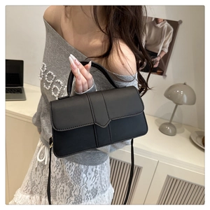 Mannequin portant un sac bandoulière en cuir noir mat au design rectangulaire moderne