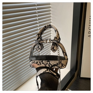 Nahaufnahme der Zebra-Handtasche mit Metallkette und Griff in Schlangenleder-Optik