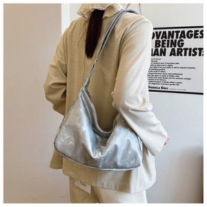 Detail of silver metallic hobo bag with vintage crinkled texture and wide shoulder strap