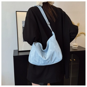 Detail of light blue crescent bag showing the adjustable strap and smooth faux suede texture