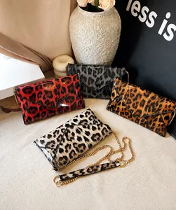 Collection of four glossy leopard print envelope bags with elegant gold chain straps