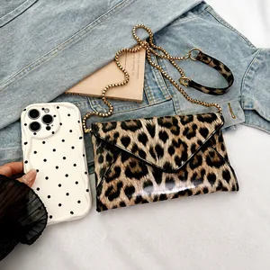 Leopard print crossbody bag size comparison with a smartphone on casual denim background