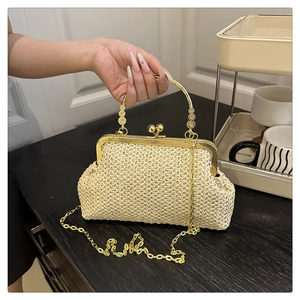 Détail d'un sac à main rétro en paille avec fermoir doré, anse ciselée et bandoulière