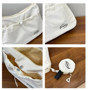 Detail view of white nylon shoulder bag with drawstring pocket and small coin purse