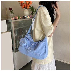 Light blue crossbody bag with drawstring, white (FASHION) text, and mini coin purse
