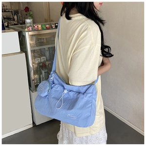 Detail of light blue nylon crossbody bag with drawstring closure and matching coin purse