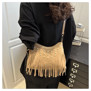 Detail of bohemian khaki suede bag featuring vintage fringe and gold stud accents