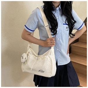 Detail of canvas crossbody bag with FASHION lettering and adjustable nylon strap on model
