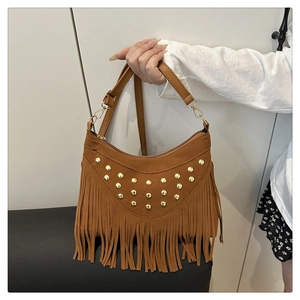 Detail of brown suede hobo bag featuring golden rivets and long fringe tassels