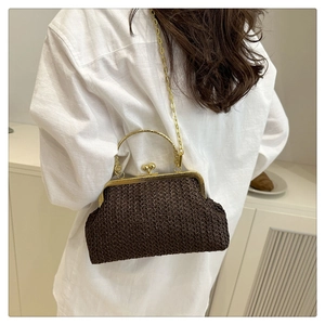 Detail of dark brown woven straw shell bag with golden metal handle and chain strap
