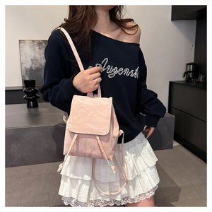 Detail view of the pink pleated texture material and drawstring design of the backpack
