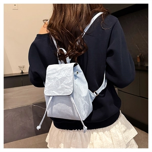 Close-up of light blue mini backpack featuring unique crinkled texture and drawstring