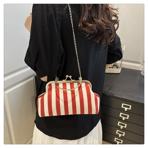 Detail of red and white striped shell bag with gold metal frame and chain strap