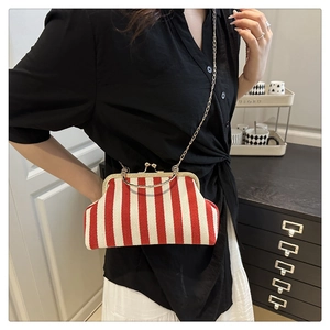 Detail of red and white striped shell bag with metal clasp and chain strap