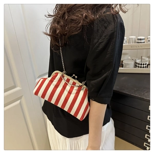 Détail du sac à fermoir vintage à rayures rouges et blanches avec bandoulière chaîne