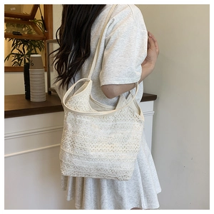 Détail du sac à bandoulière en dentelle blanche avec motifs floraux crochetés