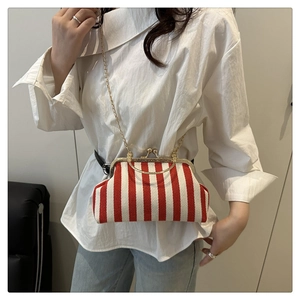 Détail d'un sac vintage à fermoir baiser avec rayures rouges et blanches et chaîne