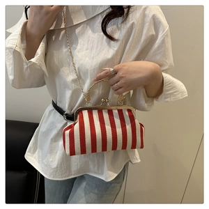 Détail du sac rétro à rayures rouges et blanches avec chaîne dorée et poignée