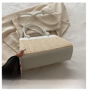 Detailansicht des weißen Lederbodens und Strohgeflechts dieser großen Handtasche