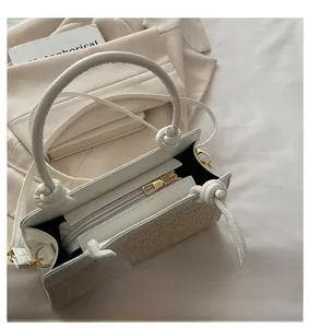 Nahaufnahme der Boho-Strohtasche mit weißem Kunstledergriff und glattem Metallreißverschluss