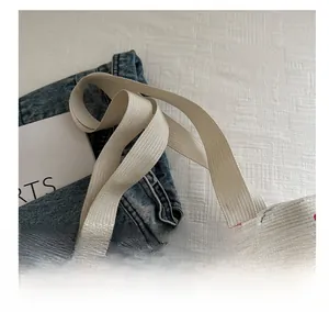 Detail showing the thick woven strap and cherry print texture on this canvas tote bag