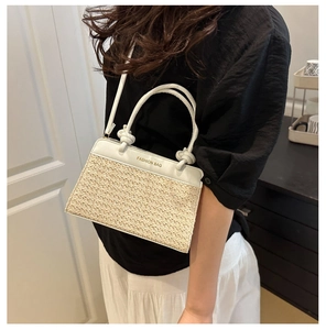 Detail of white leather and straw patchwork bag with gold Fashion Bag lettering