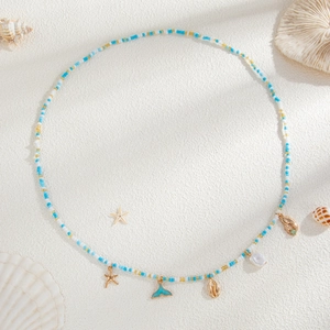 Close-up of bohemian beach waist chain with starfish, conch, and turquoise crab charms