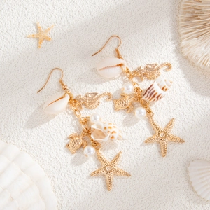 Detail von Strand-Ohrringen mit goldenem Seestern, Seepferdchen und Muschel-Anhängern