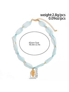 Dettaglio della collana stile oceano con maglia d'organza blu e pendente a conchiglia d'oro