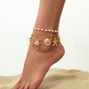 Bohemian gold chain anklet set with starfish shell pendants and white pearls on beach