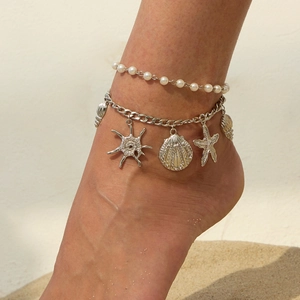 Detail of layered beach anklet featuring faux pearls and silver sea shell charms