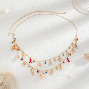 Detail of bohemian gold beach waist chain with sea shells, starfish and evil eye charms