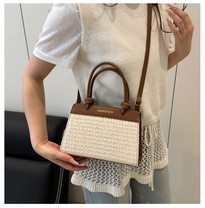 Detail der Kontrasttextur aus braunem Leder und Strohgeflecht an einer quadratischen Tasche
