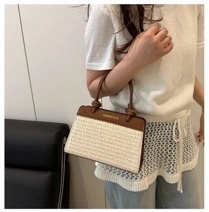 Detail of hand-woven beige bag with brown leather handles and a knot decorative strap