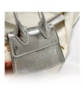 Close-up of a silver metallic mini handbag featuring a glossy crocodile embossed pattern