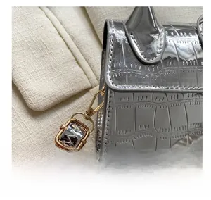 Macro shot of silver crocodile pattern handbag featuring high-quality gold metal hooks