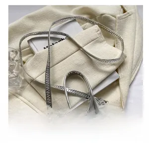 Detail showing metallic silver crocodile pattern mini handbag with adjustable strap