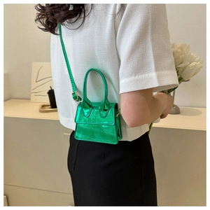 Detail view of mini bright green handbag with crocodile texture and metal gloss finish