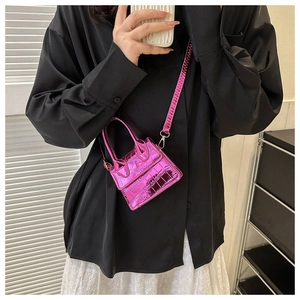 Close-up of metallic pink mini crossbody bag with crocodile pattern and top handle