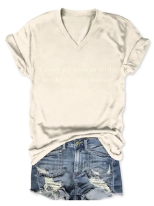 Détail d'un t-shirt beige à col en V avec imprimé et d'un short en jean délavé à plat