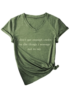 Détail du t-shirt vert armée à col en V avec slogan blanc et nœud décoratif sur le côté