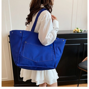 Détail du grand sac cabas bleu en toile avec coutures blanches et boutons-pression