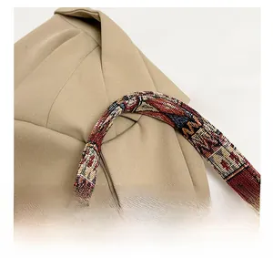 Detail of colorful ethnic woven handle on beige canvas tote bag with retro textures